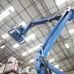 moving-stock-warehouse-with-cherry-picker-low-angle-min