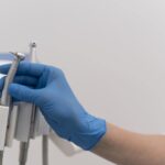 orthodontist-with-latex-glove-handling-dental-equipment-min